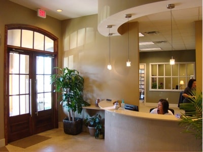 Dental office reception lobby with curved desk and pendant lighting