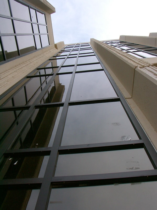 Glass and steel building facade looking upward