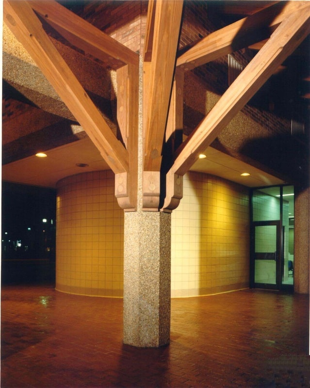 Historic building interior with exposed wood beam ceiling structure and granite column