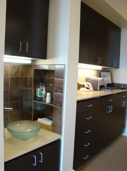 Dental operatory cabinetry with vessel sink and dark cabinets